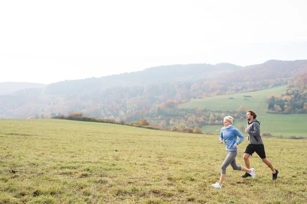 Mooie jonge paar uitgevoerd in zonnige herfst natuur. — Stockfoto