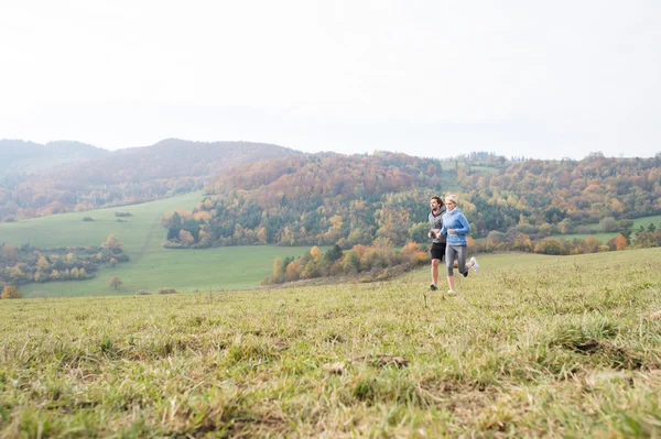 Hermosa pareja joven corriendo en la naturaleza soleada de otoño . —  Fotos de Stock