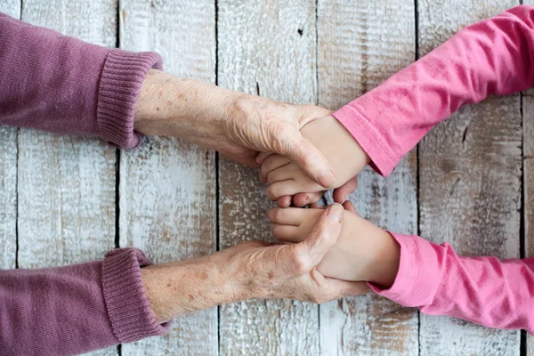 Руки неузнаваемой бабушки и внучки — стоковое фото