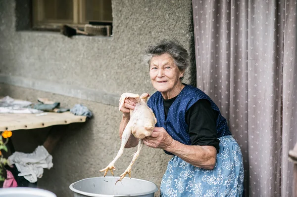 Femme âgée nettoyage et lavage du poulet . — Photo