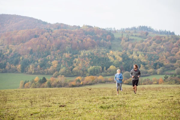 Joven pareja corriendo en otoño naturaleza . —  Fotos de Stock