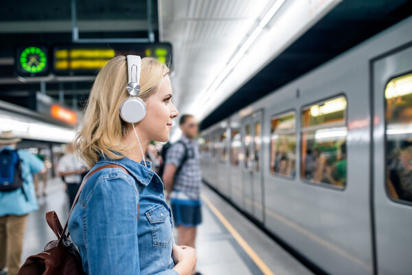 young woman at underground platform, waiting
