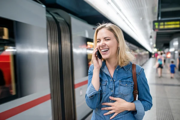 Žena s telefonem na podzemní platforma — Stock fotografie