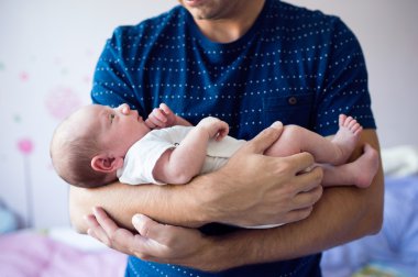 Yeni doğan bebek oğlu tutan baba
