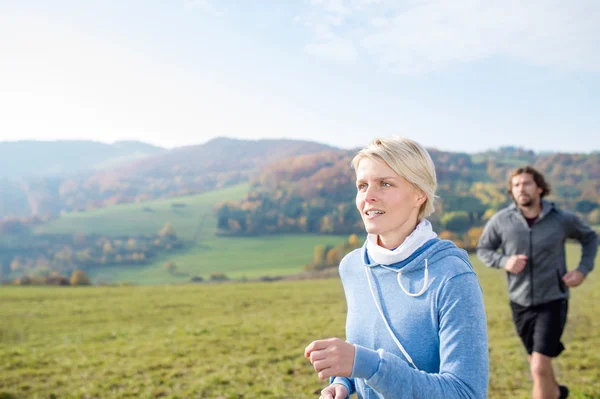 Joven pareja corriendo en otoño naturaleza . — Foto de Stock