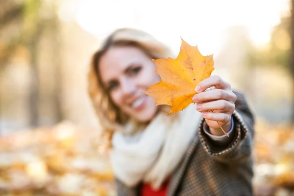 Woman holding autumn yellow leaf — Stock Photo, Image