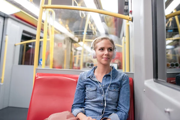 Mujer joven con auriculares en tren subterráneo —  Fotos de Stock