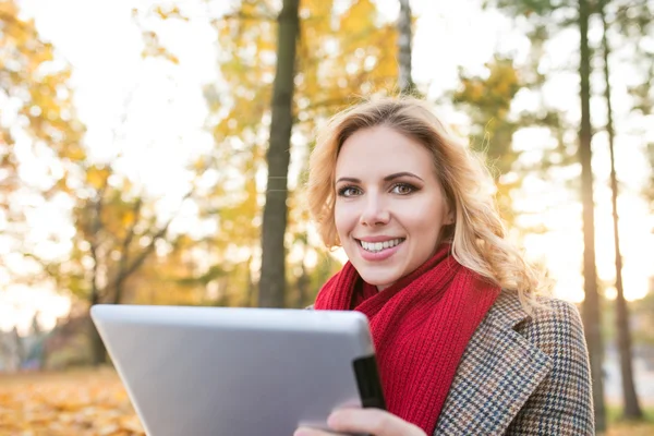 Frau mit Tablet im Herbstpark — Stockfoto