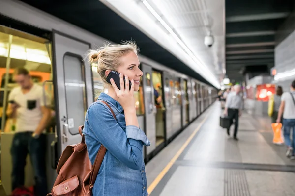 Женщина звонит по телефону на подземную платформу — стоковое фото