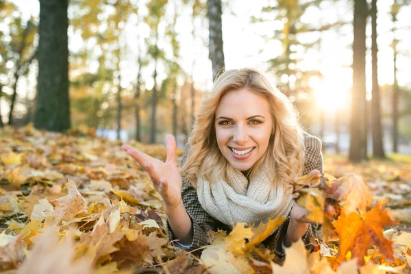 Mooie vrouw op Bladeren in de herfst park — Stockfoto