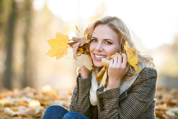 Žena sedí v podzimním parku — Stock fotografie