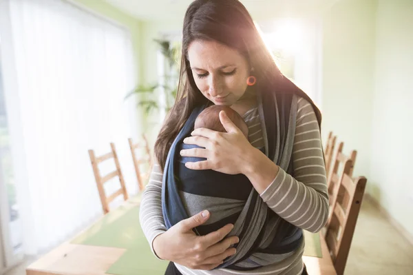 Giovane madre con suo figlio in fionda — Foto Stock