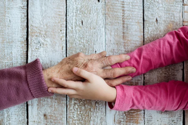 Mormor och hennes barnbarn händer — Stockfoto