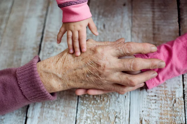 Hands of grandmother and her granddaughters — Stock Photo, Image