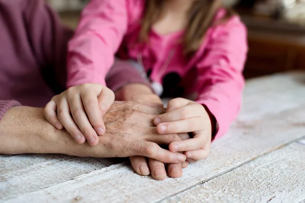 Händerna på barnbarn och hennes mormor — Stockfoto