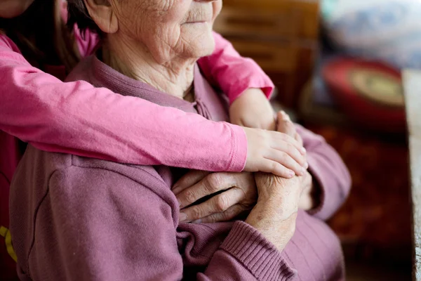 Granddaughter holding hands of her grandmother — Stock Photo, Image