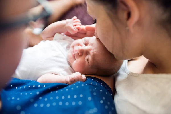 Родители целуют своего новорожденного сына — стоковое фото