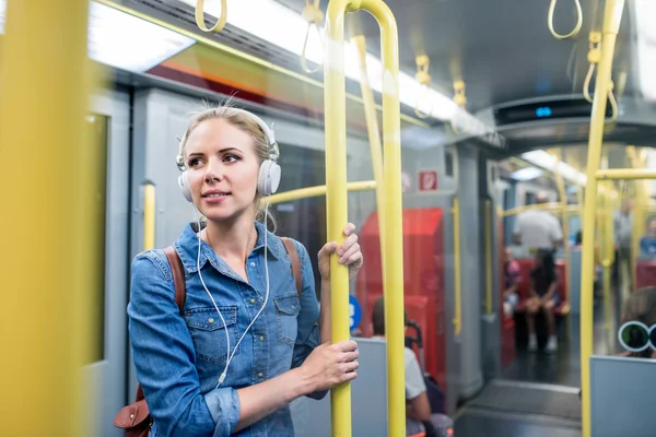 Woman with headphones in subway train — Stock fotografie