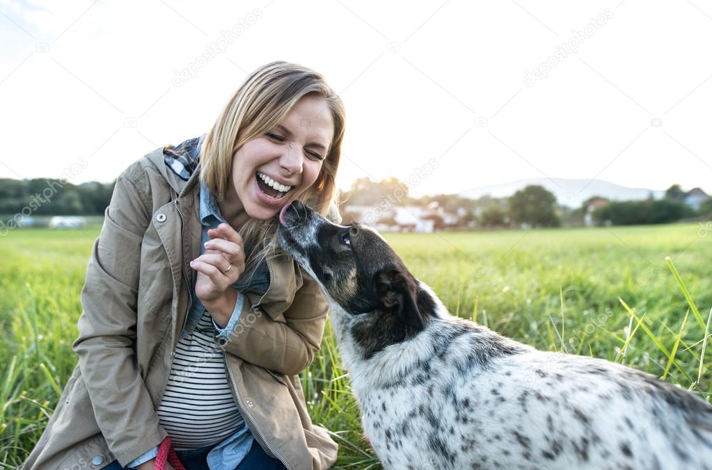 pregnant woman with dog in nature