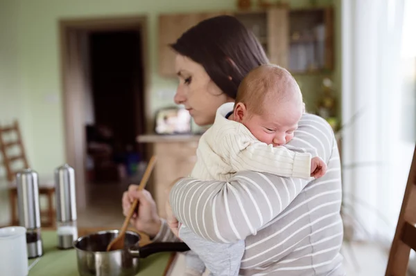 Mãe na cozinha segurando bebê filho — Fotografia de Stock