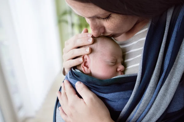 Mother kissing her son in sling — Stock Photo, Image