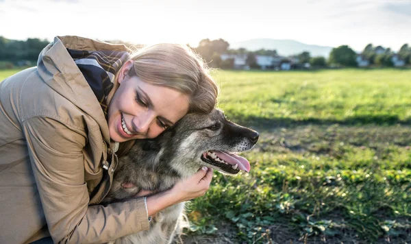 Young woman with dog in nature — Stockfoto