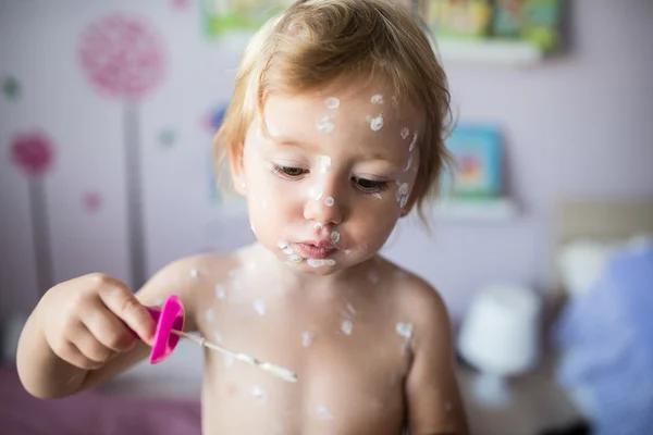 Little girl with chickenpox blowing bubbles. — Stock Photo, Image