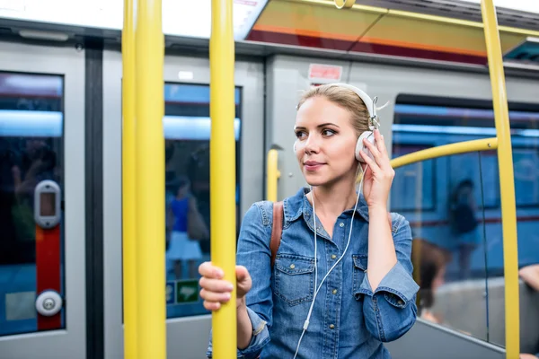 Piękna młoda kobieta z słuchawki w metrze pociąg — Zdjęcie stockowe