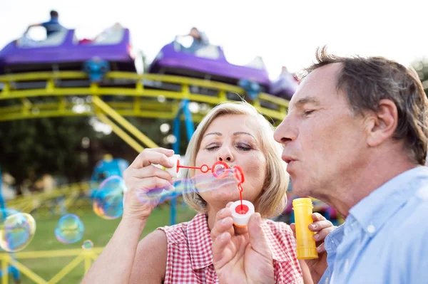 Senior couple having a good time at the fun fair — Stock Photo, Image