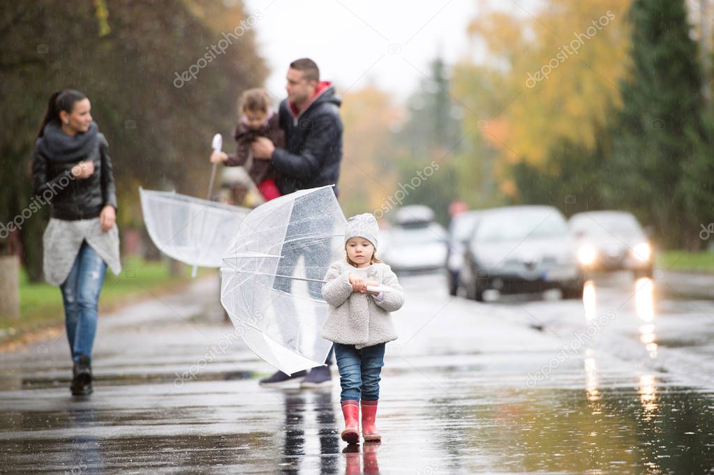 傘の下で娘と家族 雨の日の上を歩く ストック写真 C Halfpoint