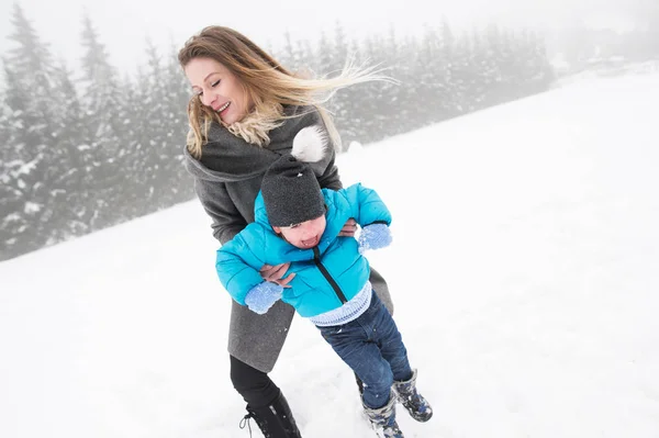 A mãe a divertir-se com o filho. Natureza de inverno . — Fotografia de Stock