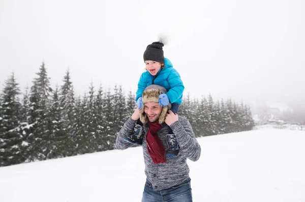 Father giving his son piggyback. Winter nature. — Stock Photo, Image