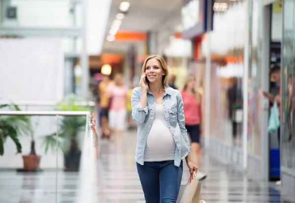 Donna incinta nel centro commerciale che fa telefonate — Foto Stock