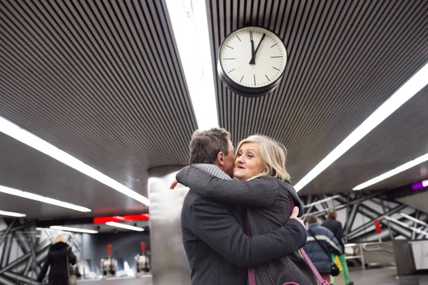 Casal sênior em pé na plataforma subterrânea, abraçando — Fotografia de Stock