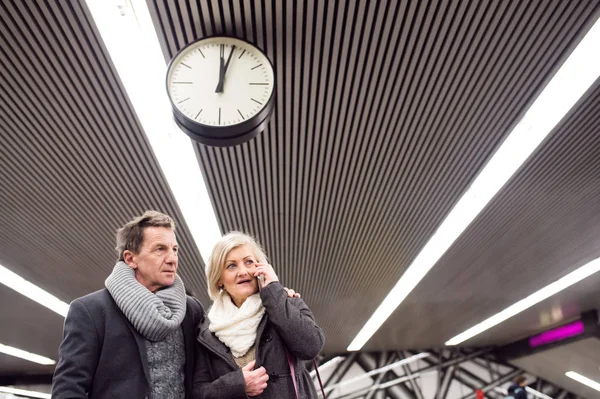 Pareja mayor parada en la plataforma subterránea, llamando — Foto de Stock