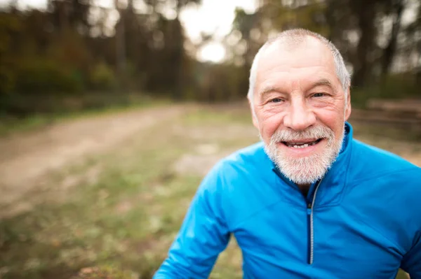 Senior löpare i naturen. Man vilar, leende. Närbild. — Stockfoto