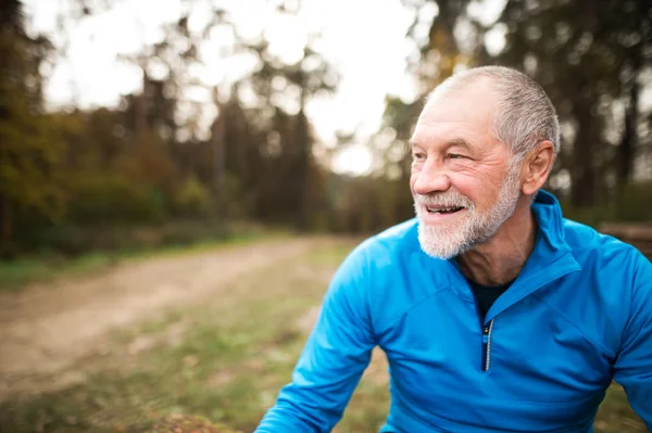 Senior löpare i naturen. Man vilar, leende. Närbild. — Stockfoto