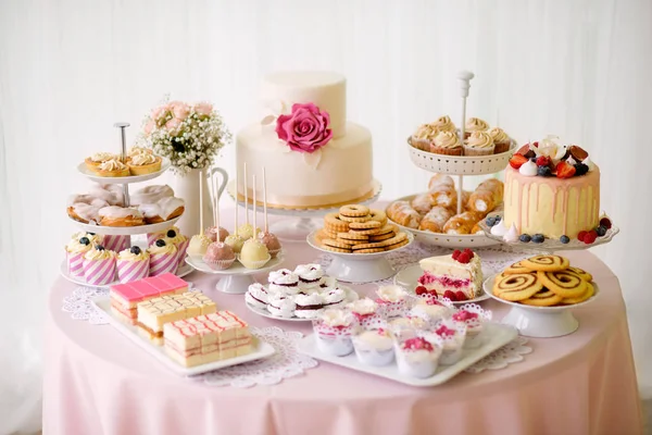 Tisch mit vielen Kuchen, Cupcakes, Keksen und Cakepops. — Stockfoto