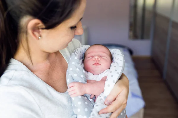 Beautiful mother holding newborn baby son in her arms — Stock Photo, Image