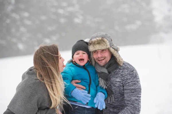 Vader en moeder met hun zoon, spelen in de sneeuw. — Stockfoto