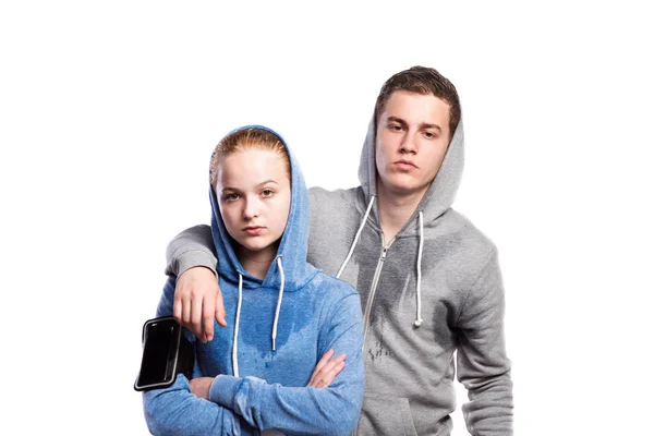 Tiener jongen en meisje in sweatshirts. Studio schot, geïsoleerd. — Stockfoto