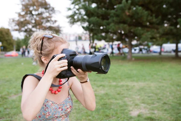 写真を撮るプロのカメラを持つ若い女性. — ストック写真