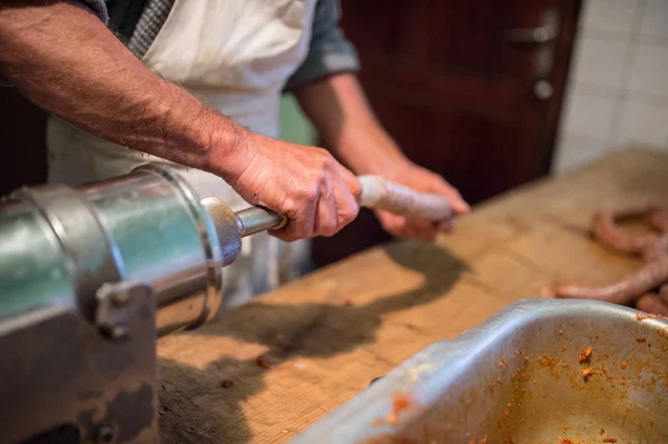 Uomo che fa salsicce il modo tradizionale con insaccatrice . — Foto Stock