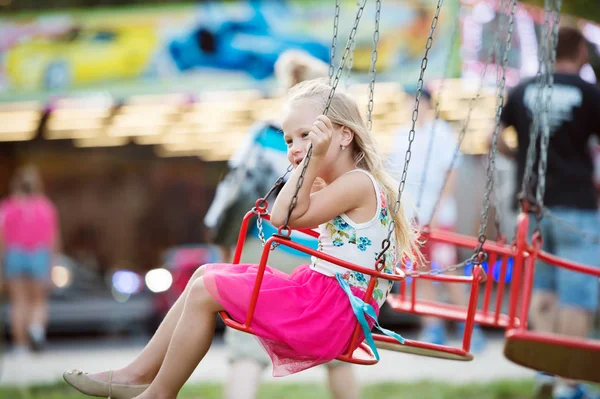 Χαριτωμένο μικρό κορίτσι στο λούνα παρκ, αλυσίδα swing ride — Φωτογραφία Αρχείου