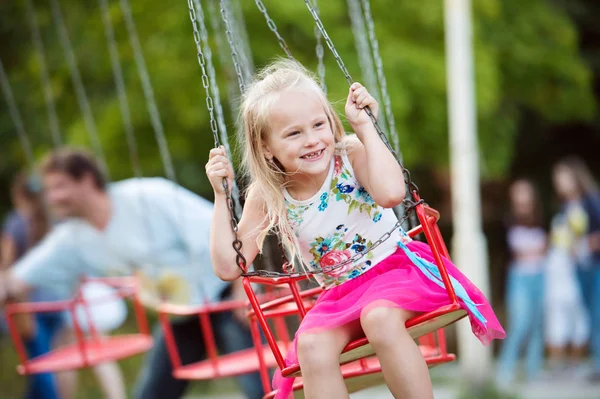 Χαριτωμένο μικρό κορίτσι στο λούνα παρκ, αλυσίδα swing ride — Φωτογραφία Αρχείου
