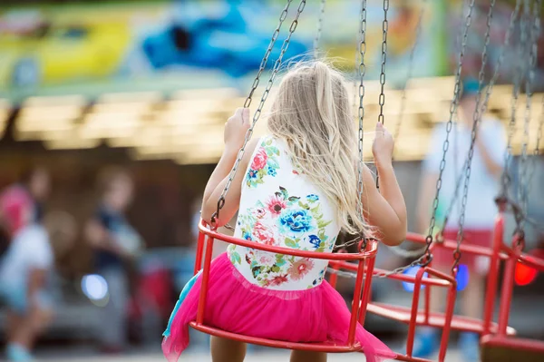 Schattig klein meisje op de kermis, keten schommel rit — Stockfoto