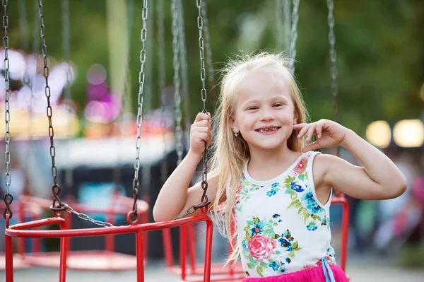 Carino bambina al divertimento fiera, catena swing ride — Foto Stock