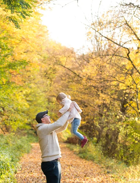 父亲抱着小女儿，把她扔在空气中 — 图库照片