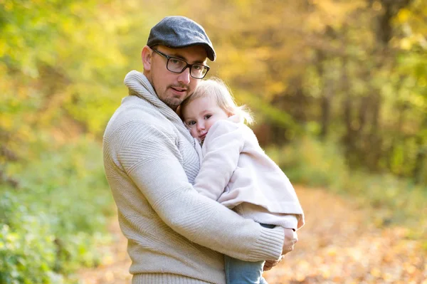 Küçük kızı onun kollarında tutan baba. Sonbahar doğa. — Stok fotoğraf