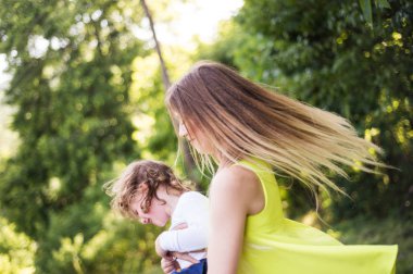 Güzel Anne oğlunu iplik. Güneşli yaz doğa.